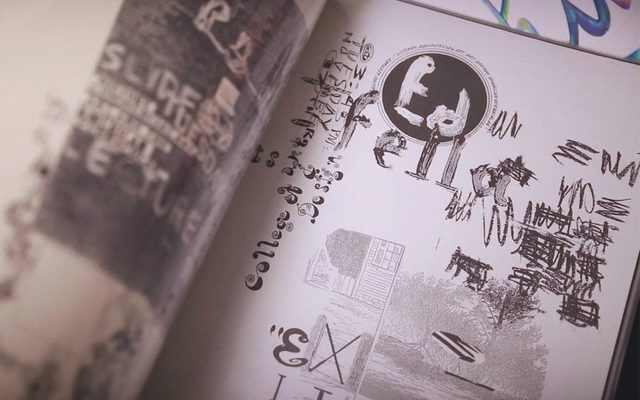 A book open to a page with sketches and scribbles reading Ed Fella in black and white ink