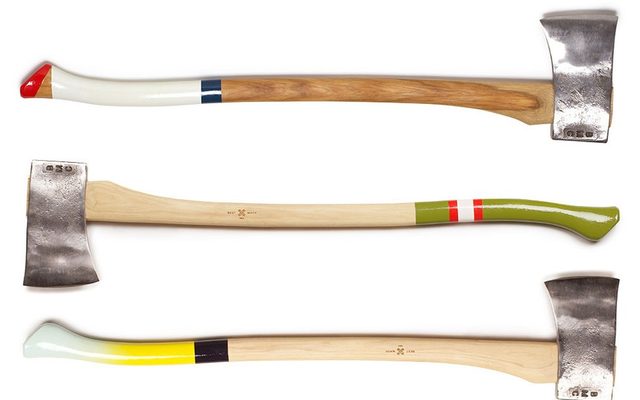 3 axes with painted handles artfully displayed on a white surface
