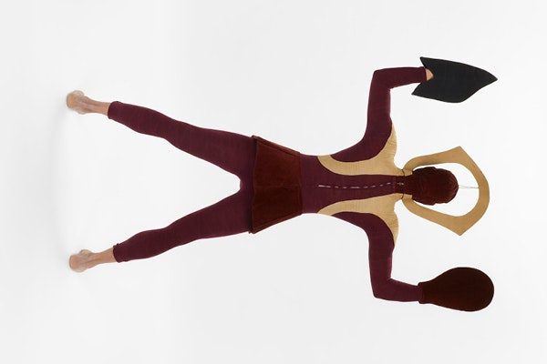 The back of a live performer wearing a burgundy and tan costume with a sculptured head piece and mitts