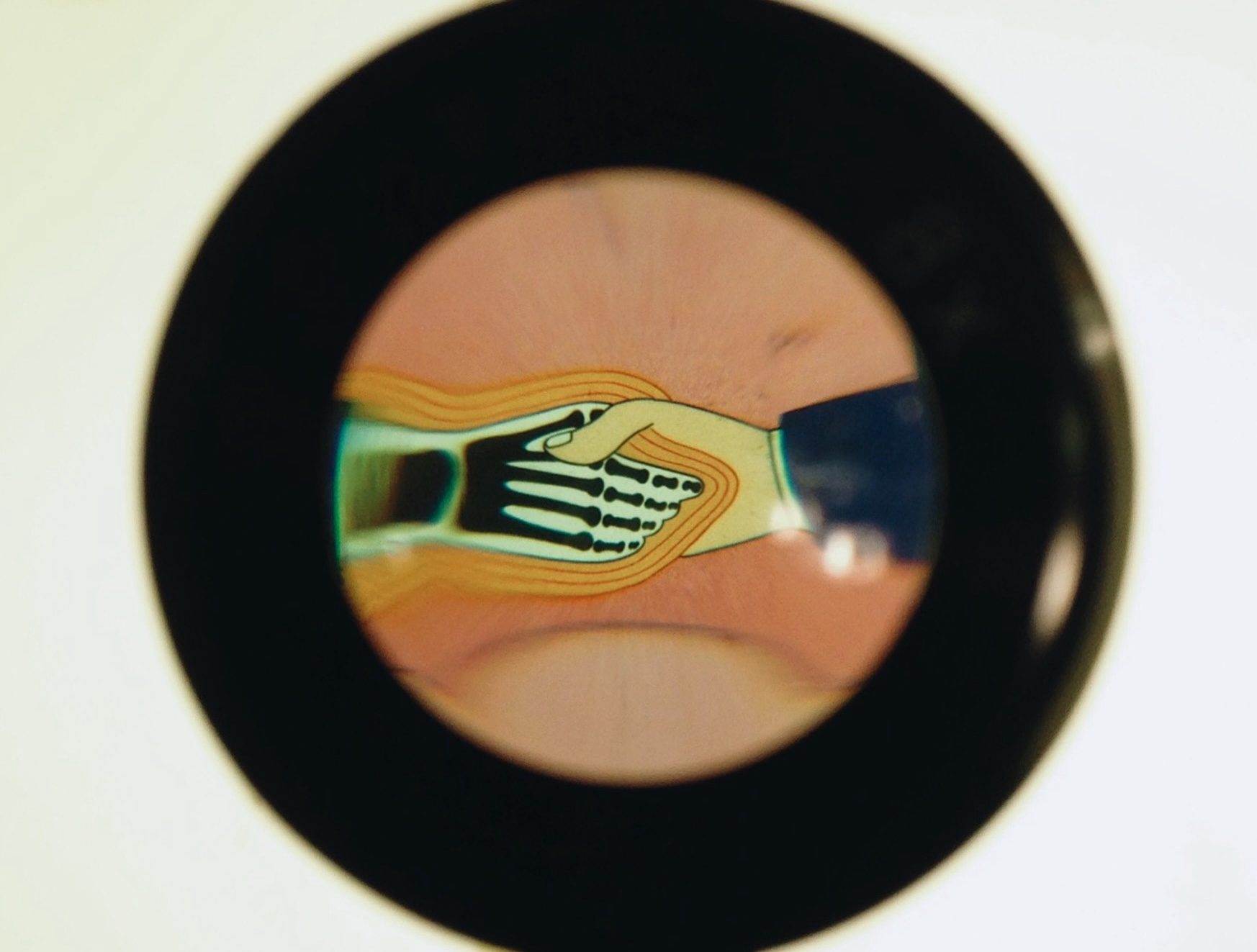 a thick black outlined circle with cartoon of a human hand shaking a black and white skeletal hand with orange outlines surrounding it
