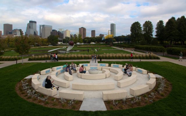 The Walker-commissioned piece, titled Okciyapi (2021), is the first public artwork by a Native artist to be sited in the Garden. Both a gathering place and participatory work, the sculpture is composed of rings of seating elements surrounding a central water feature.