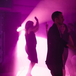 People dancing in a purple lit room at a Walker Art Center event