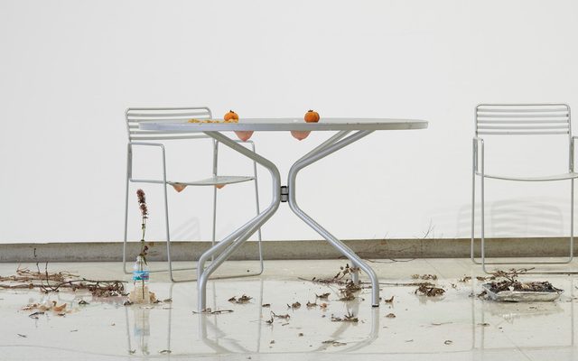 patio table with with two oranges on it