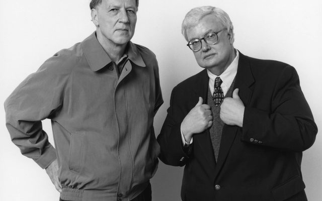 Two adults in coat stand and pose for the camera