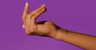 A hand with light brown skin is poised to snap its fingers against a solid purple background. The thumb and middle finger are pressed together, while the index finger is extended upward.