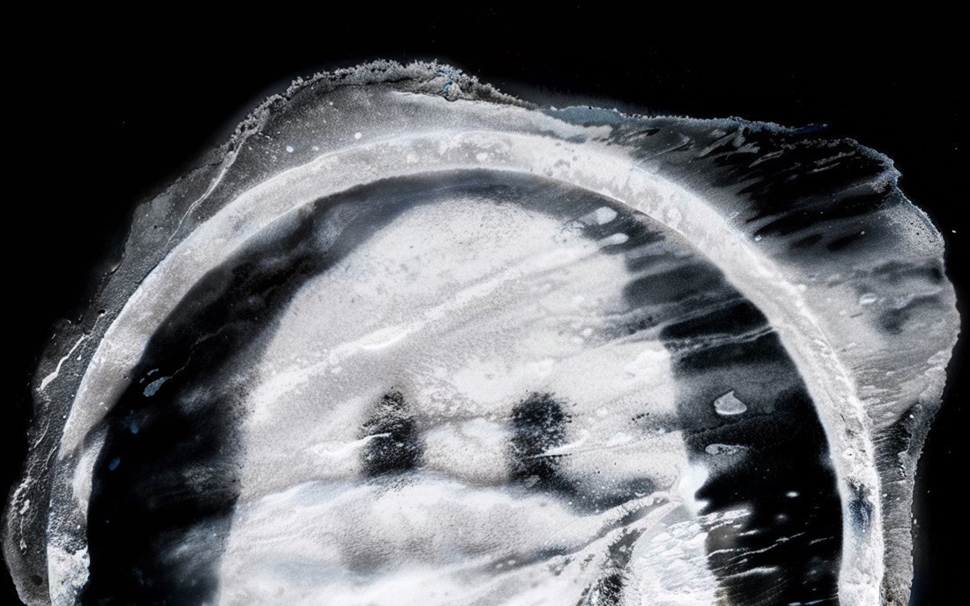 Abstract monochrome image featuring swirling patterns resembling clouds or waves. It suggests a mysterious, ethereal scene against a dark background.