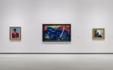 A gallery wall with three paintings on the wall.