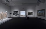 A dimly lit art gallery with mannequins in light dresses on the left, black-and-white photos on the walls, a bench in the center, and a video projection on the right wall. A bright doorway leads to another room.